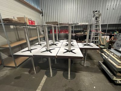 many tables and chairs in a warehouse with a lot of boxes