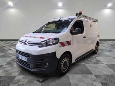 la camionnette blanche est garée dans une grande pièce au sol en damier