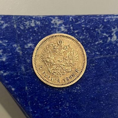 une pièce d'or posée sur une table en marbre bleu