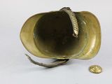 a gold cup with a leaf on it next to a coin