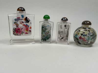 three glass bottles with different designs on them sitting on a white surface