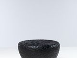 une photo d'un bol noir posé sur une table blanche