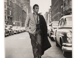 black and white photograph of a man walking down the street