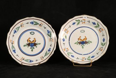 two plates with blue and green designs on them on a black background