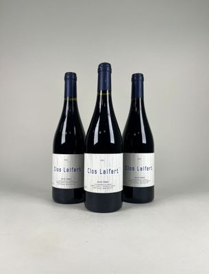 three bottles of red wine sitting next to each other on a table