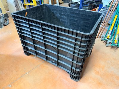 a black plastic container sitting on the floor in a garage
