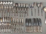 de nombreuses cuillères et fourchettes disposées sur la table