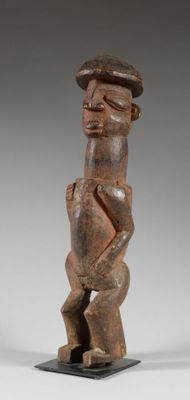 une statue en bois d'un homme avec un chapeau sur la tête