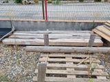 a pile of wooden pallets on the ground next to a fence