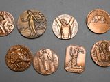 six different types of bronze medals on a gray surface