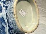 a blue and white vase sitting on a white surface