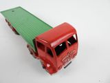 a red and green toy truck on a white surface