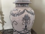 un vase blanc et bleu avec un couvercle, posé sur une table