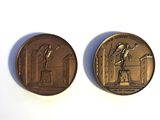 two bronze coins with a statue on top of them on a white surface
