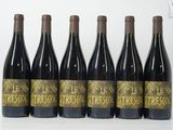 six bouteilles de vin rouge sont alignées sur une table