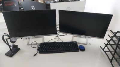 deux écrans d'ordinateur et un clavier sur un bureau