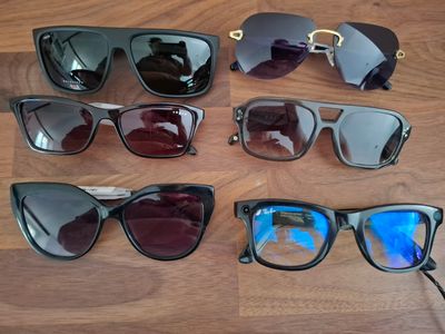 Plusieurs paires de lunettes de soleil sont alignées sur une surface en bois