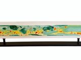abstract painting on glass on a black stand on a white background