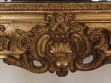 a clock that is on top of a gold mantle