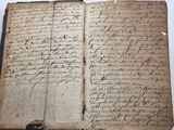 an old book with writing on it sitting on top of a table