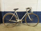 a white bicycle parked against a wall in a garage