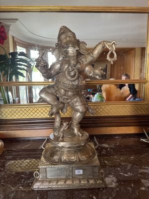 une statue d'éléphant posée sur un socle devant un miroir