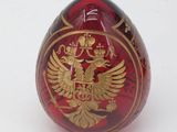 a red and gold egg with a gold eagle on it