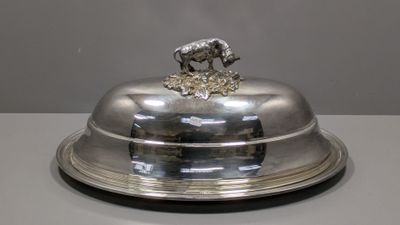 un plateau en argent orné d'un cheval, posé sur une table
