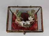 a glass box with a crown of flowers inside of it