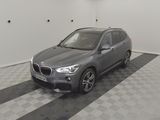 the bmw x1 is parked in a garage with a checkered floor