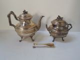 a silver tea pot and a silver teapot on a table