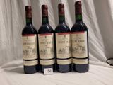 three bottles of red wine are lined up on a table