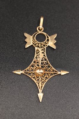 gros plan d'une croix en or sur une surface noire
