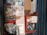 une boîte en métal remplie d'objets divers, posée sur une étagère