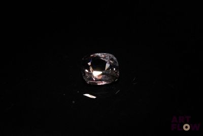 a close up of a diamond on a black surface in the dark
