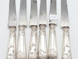 five silverplated knives with ornate handles and handles