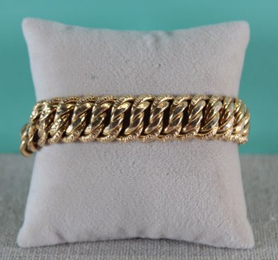 un bracelet en or posé sur un oreiller, avec un oreiller en arrière-plan