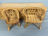 two wicker chairs and a table with a blue background