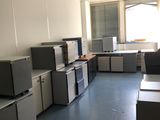 une pièce où se trouvent de nombreux bureaux et armoires