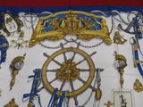 a blue and gold scarf with a picture of a ship wheel on it
