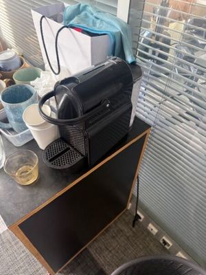 une cafetière noire posée sur une table en bois