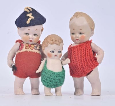 three little dolls that are standing next to each other