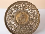 brass plate with a picture of a woman on it on a white surface