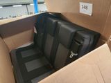 a black seat in a cardboard box with a tag on it