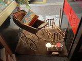 une poussette miniature avec des livres exposés dans une vitrine