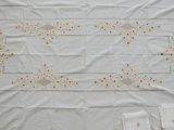 a white table cloth with red and yellow flowers on it