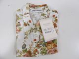 the shirt is white with a floral pattern and has a tag on it