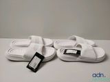 Sandales blanches adidas de type « slides » avec une étiquette sur le côté