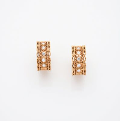 une paire de boucles d'oreilles en or et diamants sur fond blanc