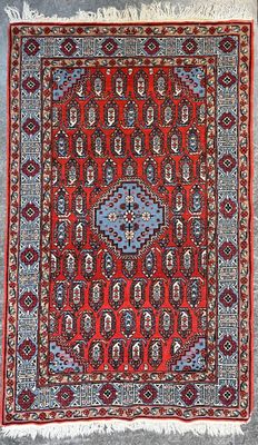 un tapis rouge et bleu à motifs de médaillons